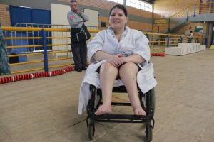 Mariele Zenaide dos Santos em uma cadeira de rodas, usando um roupão branco